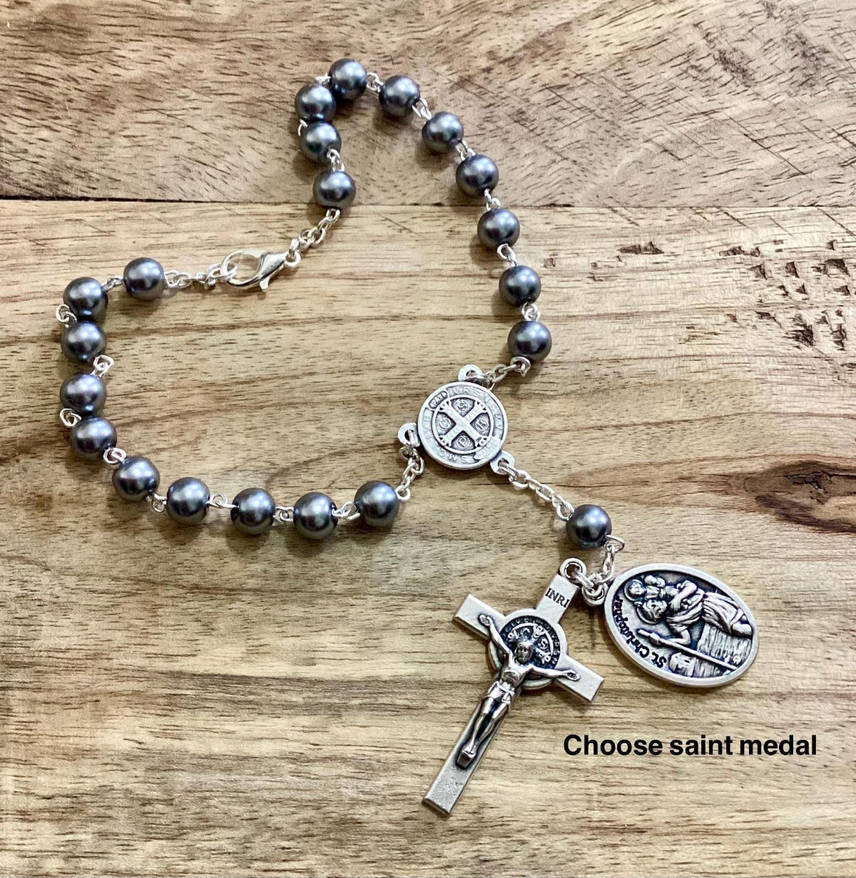 Car rosary hanging from rearview mirror with crucifix and medal