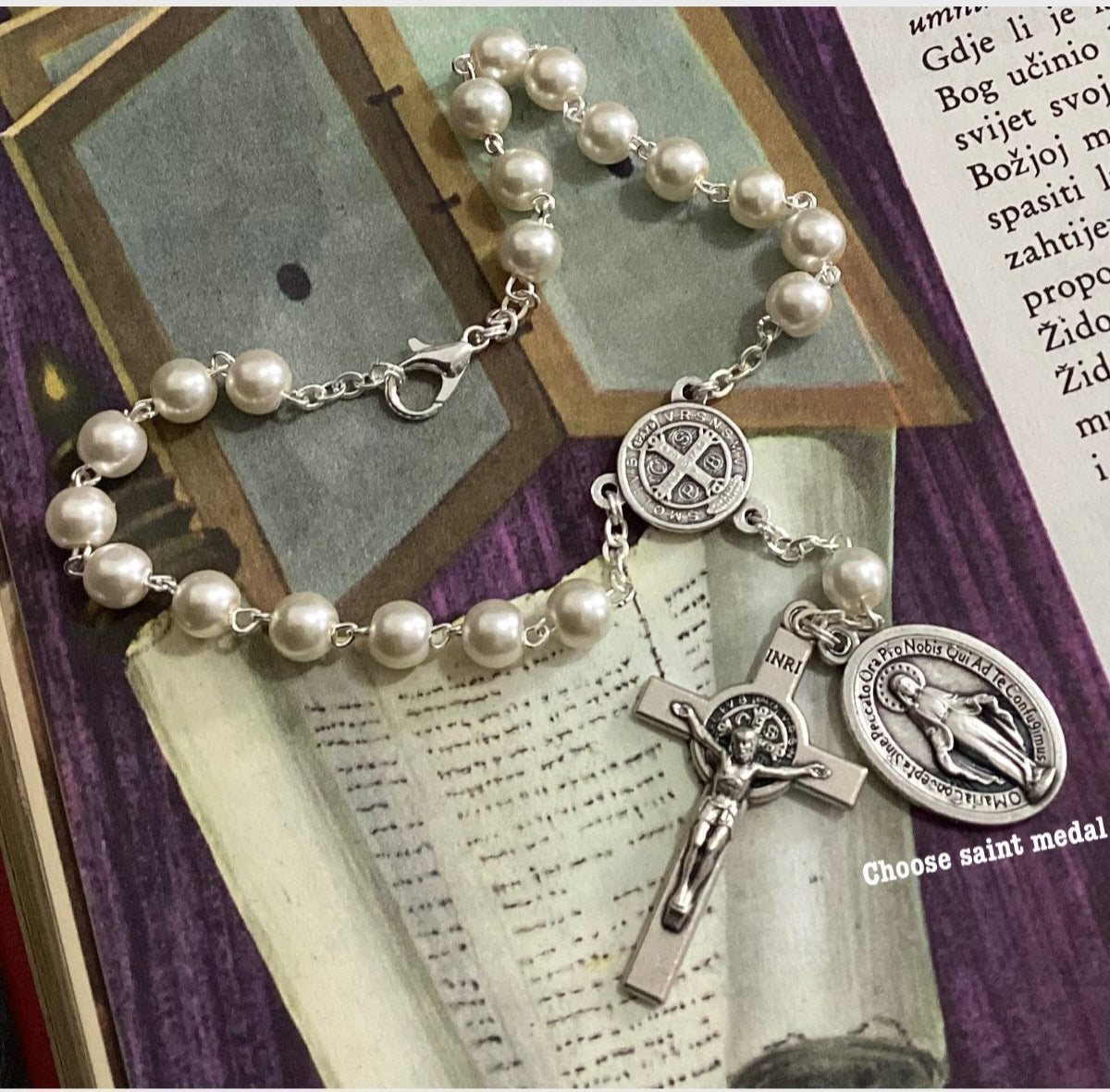 Car rosary hanging from rearview mirror with crucifix and medal