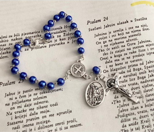 Car rosary hanging from rearview mirror with crucifix and medal
